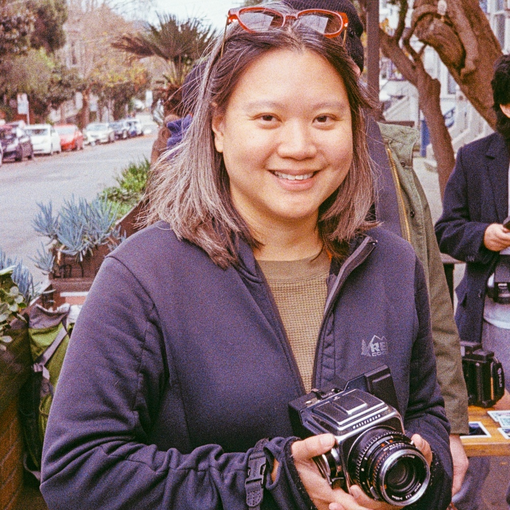 a photo of adrianna holding a hasselblade camera and smiling